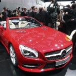 A worker removes fingerprints from the 2013 Mercedes Benz SL on the first press preview day at the North American International Auto Show in Detroit