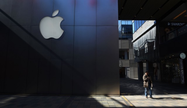 A man walks past an Apple store in Beijing on February 18, 2016. Apple on February 18 launched its mobile payments service Apple Pay in China, pitting the US technology giant against strong domestic players in an already crowded field. AFP PHOTO / GREG BAKER / AFP / GREG BAKER (Photo credit should read GREG BAKER/AFP/Getty Images)
