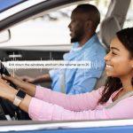 Enjoying Travel Concept. Smiling beautiful African American woman driving modern luxury car, happy young man sitting on the front passenger seat, looking on the road, family going on road trip