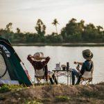 Cheerful Young Couples camping with morning coffee.
